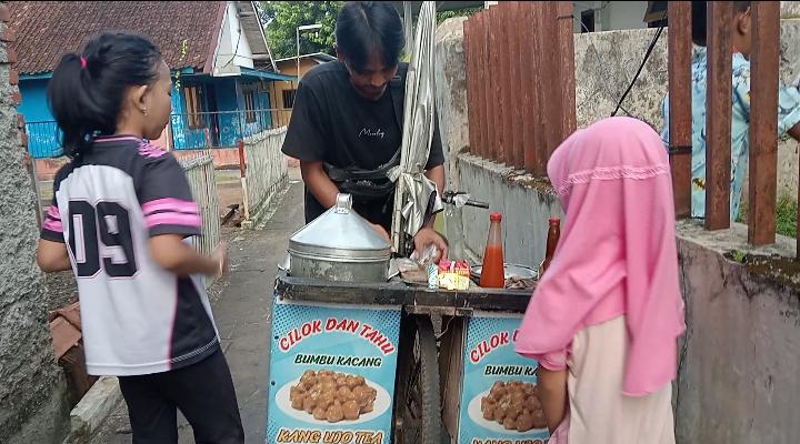 Image of Ujo, pedagang cilok bersepeda yang bertahan di tengah sepi pembeli